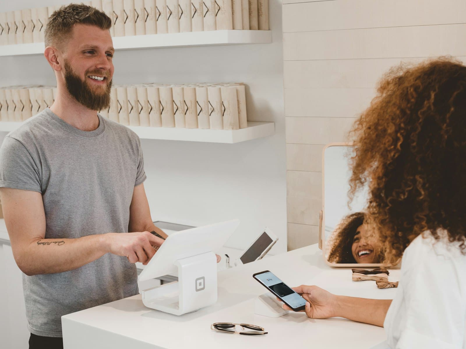 A store owner processing a customer's payment at checkout
